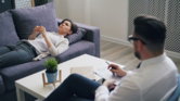 a-man-sitting-on-a-couch-next-to-a-woman.jpg a man sitting on a couch next to a woman
